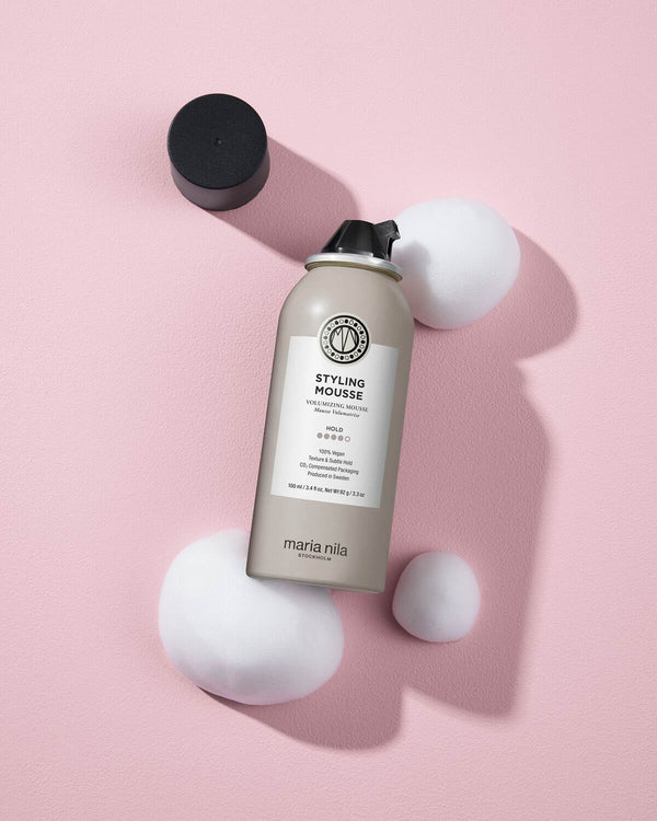 Marina Nila styling mousse bottle on a pink background
