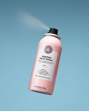 Pink can of Maria Nila shaping heat spray on a light blue background