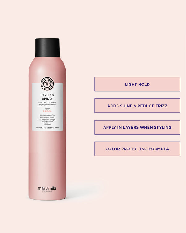 Pink bottle of Maria Nila styling spray on a light pink background with product details.