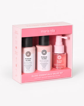 Hair care gloss essentials set with shampoo, conditioner, and styling spray in pink packaging.