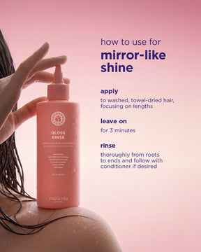 Pink bottle of Mirror Gloss Rinse with pump held over wet hair strands against a soft background.